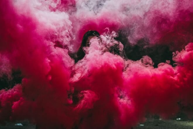 A woman surrounded by red smoke