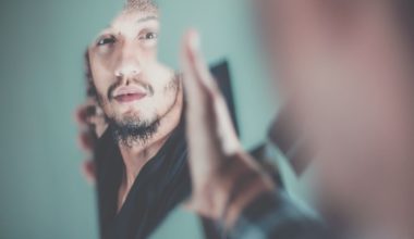 man looking at his own reflection in the mirror