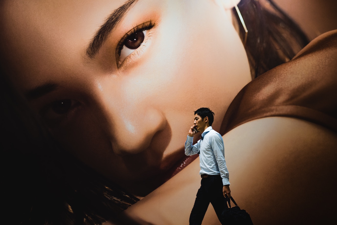 Billboard of woman towering over man on his phone as metaphor for Relationship OCD