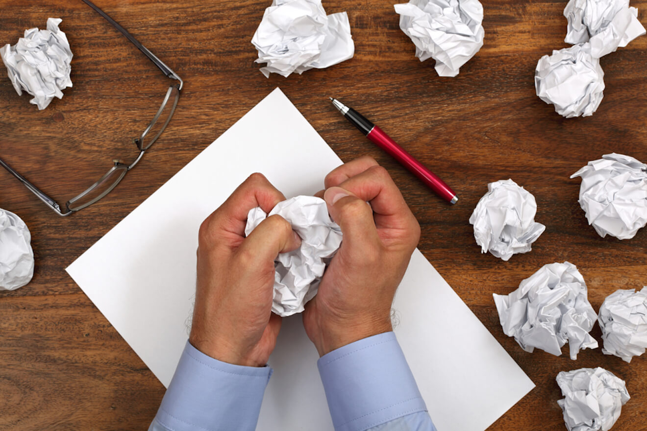 Frustrated person writing unsuccessfully