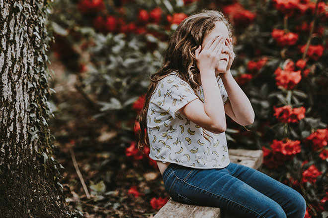 Girl with hands over her eyes