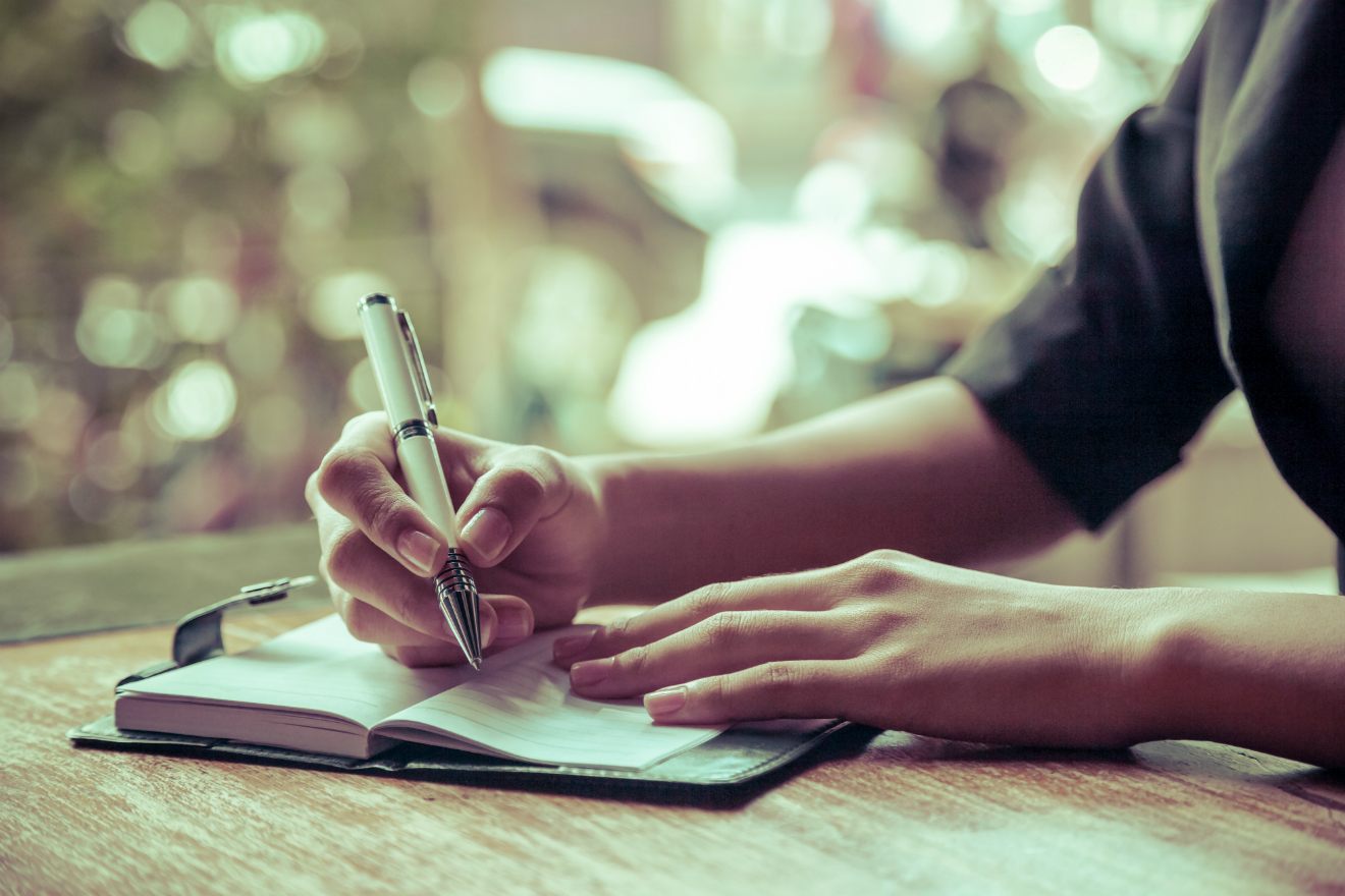 woman writing pen table journal