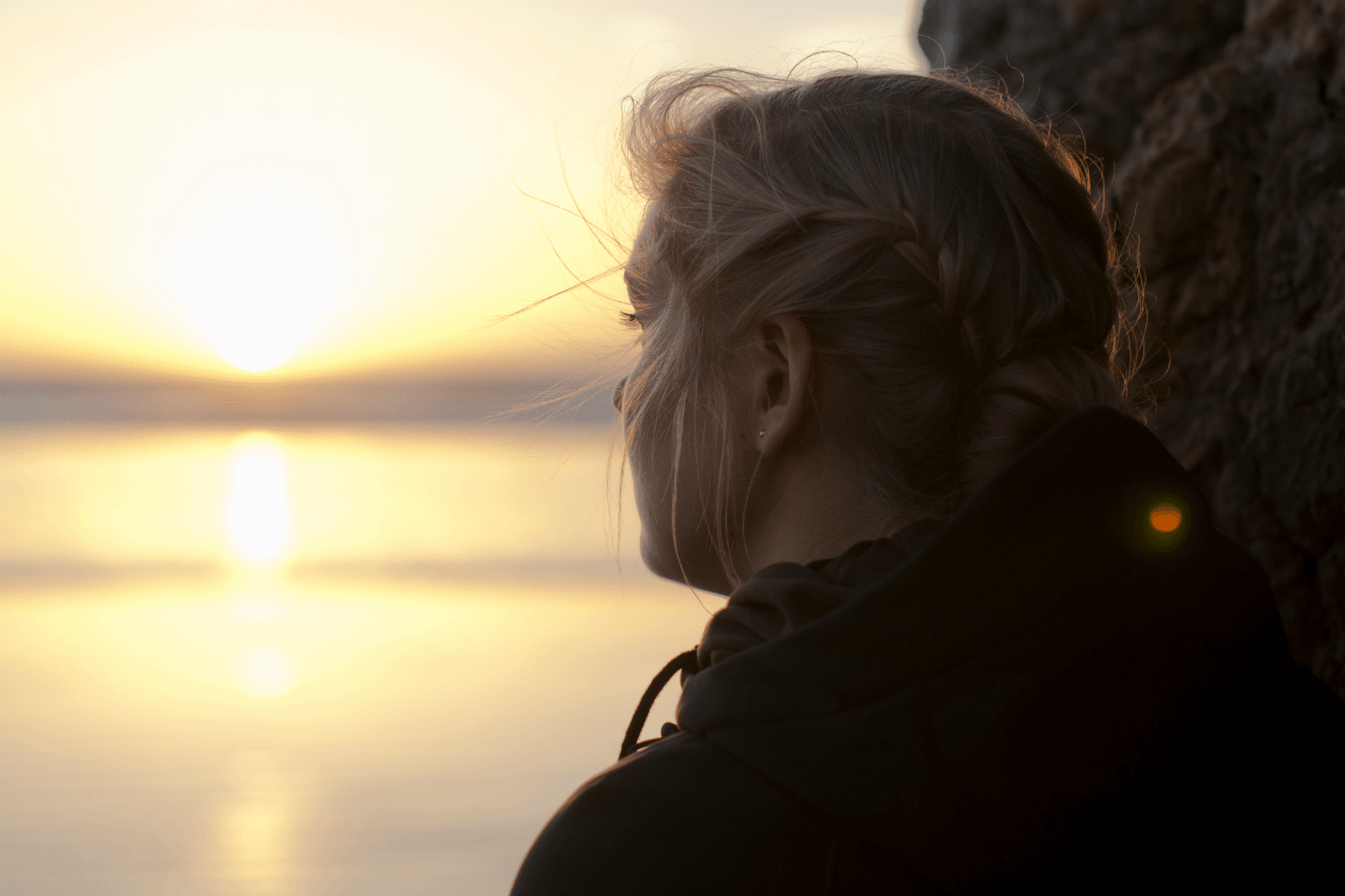 sad woman looking into sunset